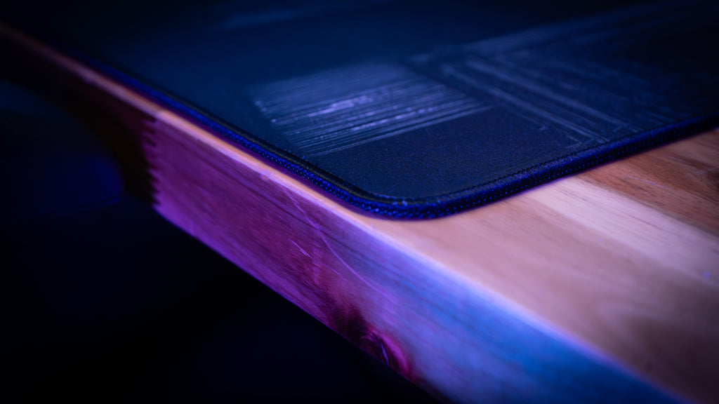 Close-up of a blue mouse pad on a wooden surface with a dark background