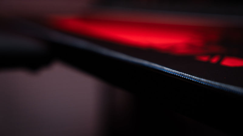 Tight macro shot of stitching on a red Rust desk mat