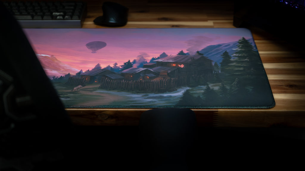 Desk setup with a large mouse pad featuring a scenic design on a wooden desk.