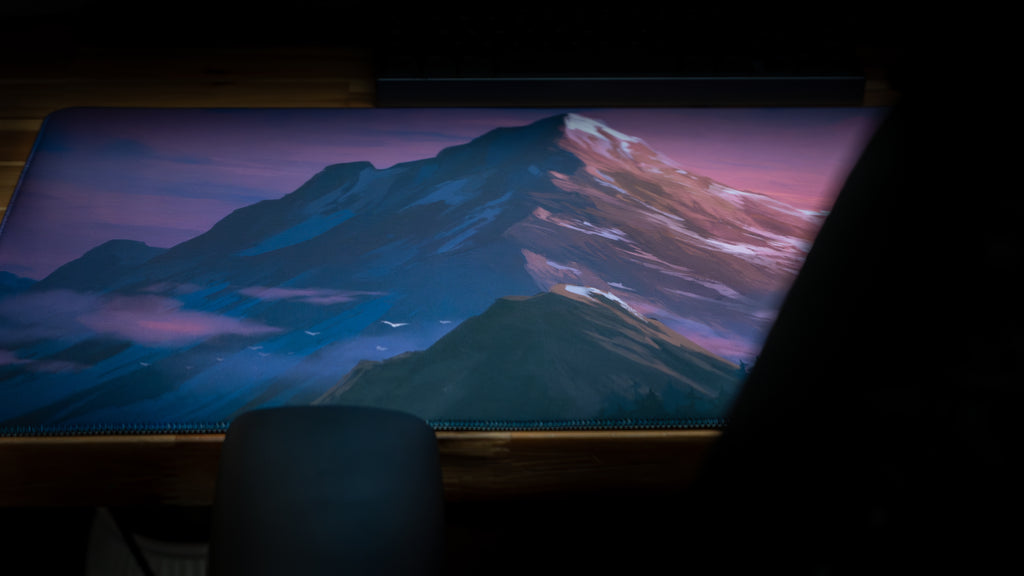 Laptop displaying a mountainous landscape on a dark background