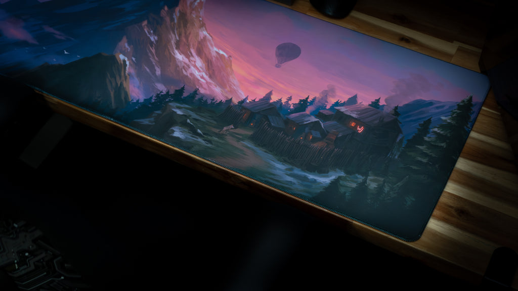 Large mouse pad with a scenic design of mountains and a hot air balloon on a wooden surface.