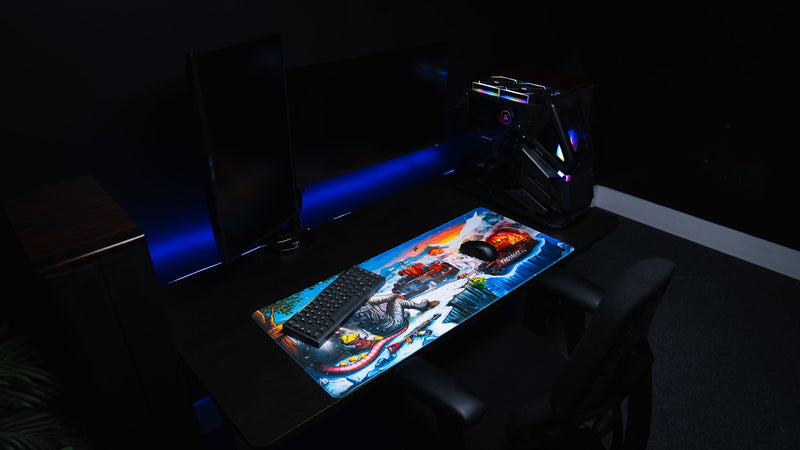 A Solo's Kingdom gaming deskmat by Gorliac displayed on a dual-monitor gaming desk setup with a mechanical keyboard, mouse, and RGB PC.