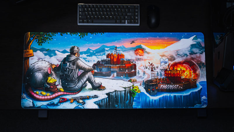 Top-down view of the A Solo's Kingdom gaming deskmat by Gorliac featuring a lone Rust survivor overlooking snowy bases, a giant rat, and a fiery island fortress.