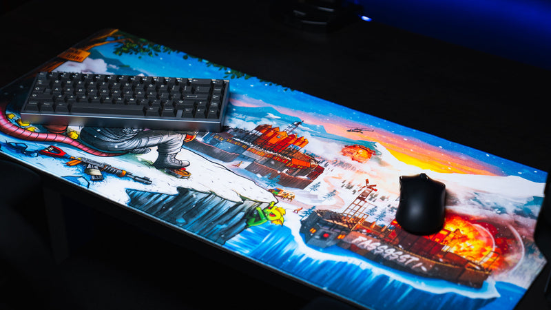 A Solo's Kingdom gaming deskmat by Gorliac featuring a snowy Rust battlefield with fortified bases, explosions, helicopters, and a cliffside survivor.