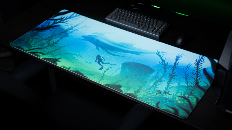 Wide view of Alidove's Lurking Leviathan gaming deskmat with blue-green underwater artwork, a diver and tall kelp.