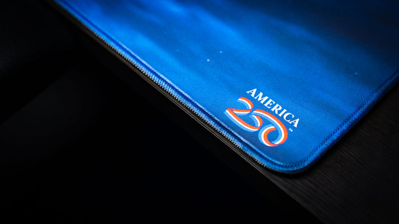 Close-up of the America 250 logo on the Nightsky Death Bowl deskmat, highlighting the vibrant print quality, stitched edge, and premium gaming mouse pad construction.