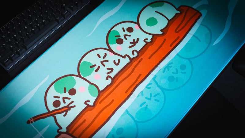 Angled close-up of four fishing frogs and their reflections on the Frogs on a Log desk mat