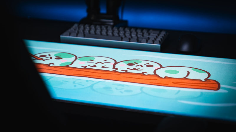 Low-angle view across the Angyfrog Frogs on a Log desk mat showing four frogs on a floating log