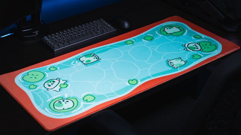 Angled full view of the Angyfrog The Pond desk mat with keyboard and frog pond artwork