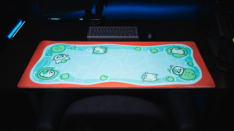 Front view of the full Angyfrog The Pond desk mat centered beneath a keyboard on a dark desk