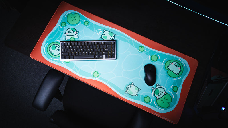 Overhead view of keyboard and mouse arranged on the colorful Angyfrog The Pond desk mat