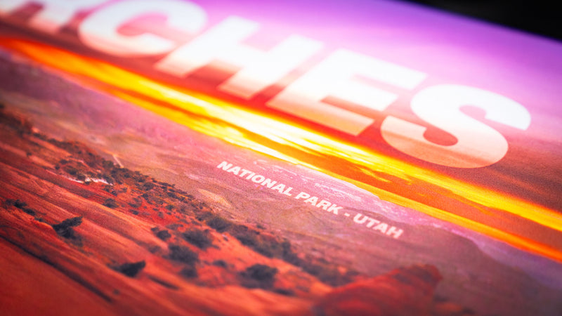 Close-up detail of the Arches National Park premium deskmat featuring Delicate Arch at sunset with vivid colors, crisp landscape photography, and a smooth cloth surface.