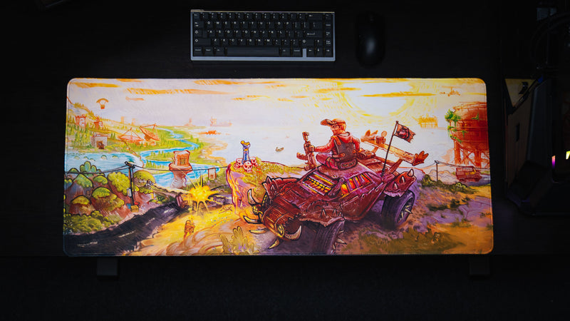 Top view of the full Rust After Glory desk mat showing the armored vehicle and colorful coastal battlefield