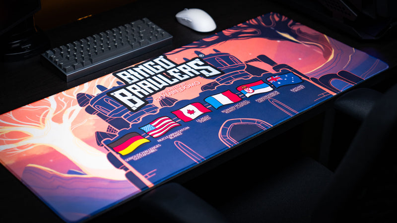 angled view of the Bingo Brawlers Season 6 Commemorative Deskmat displayed on a gaming desk with keyboard.