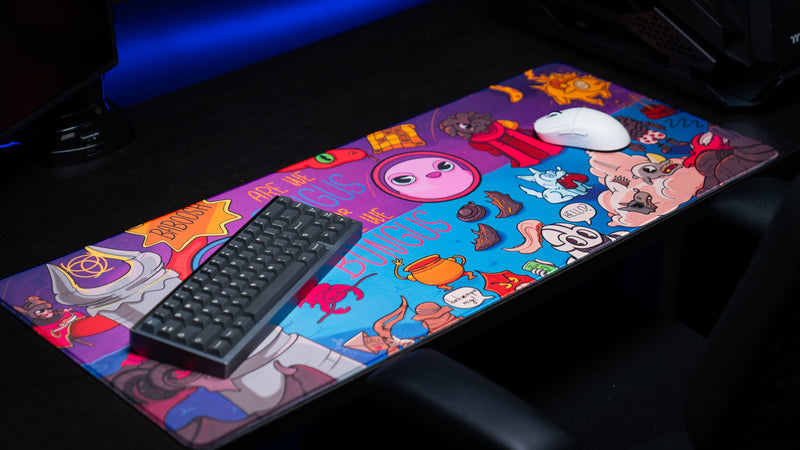 Angled desktop view of the Bingus Bongus deskmat showing the complete artwork displayed across a premium gaming workspace.