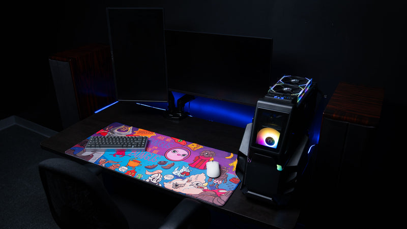 Angled gaming desk setup featuring the Bingus Bongus deskmat with mechanical keyboard, wireless mouse, RGB PC lighting, and full artwork visibility.