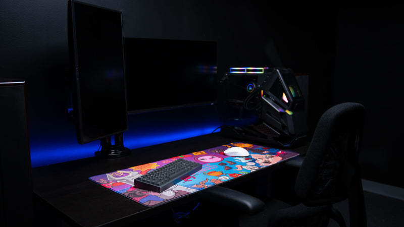 RGB gaming desk showcase with the Bingus Bongus deskmat highlighting vibrant artwork, premium surface material, and colorful design elements.