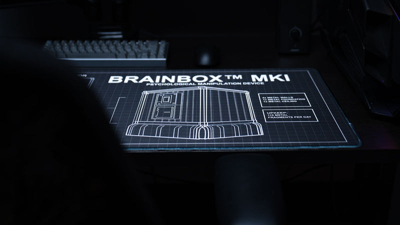 BRAINBOX MK1 deskmat featuring a technical blueprint of a Rust metal base with upkeep information and engineering-style schematics.