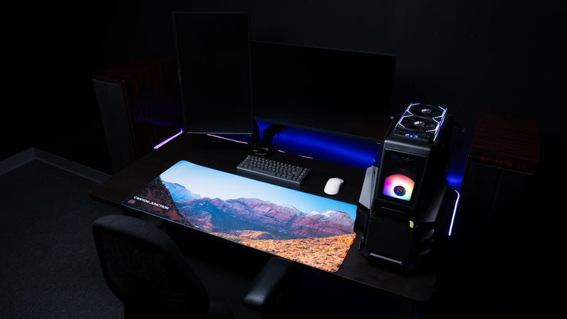 Canyon Junction deskmat displayed in a modern gaming desk setup, showcasing Zion National Park's dramatic canyon landscape with vibrant HD photography and premium stitched edges.
