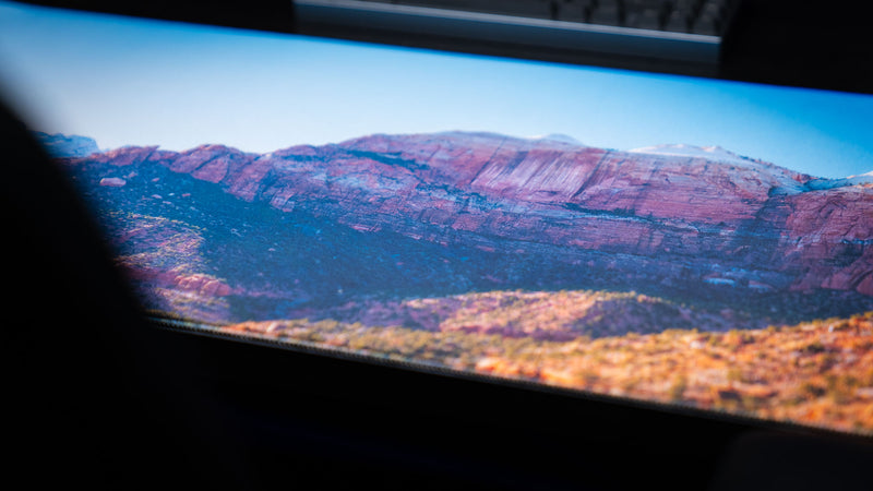 Close-up of the Canyon Junction deskmat showcasing Zion National Park's panoramic sandstone cliffs with vibrant HD photography, premium stitched edges, and a smooth gaming surface.