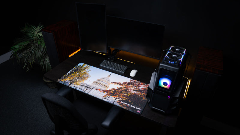 Wide-angle gaming desk setup featuring the Capitol Building deskmat with the U.S. Capitol and colorful autumn trees, displayed on a premium extended mouse pad with stitched edges.