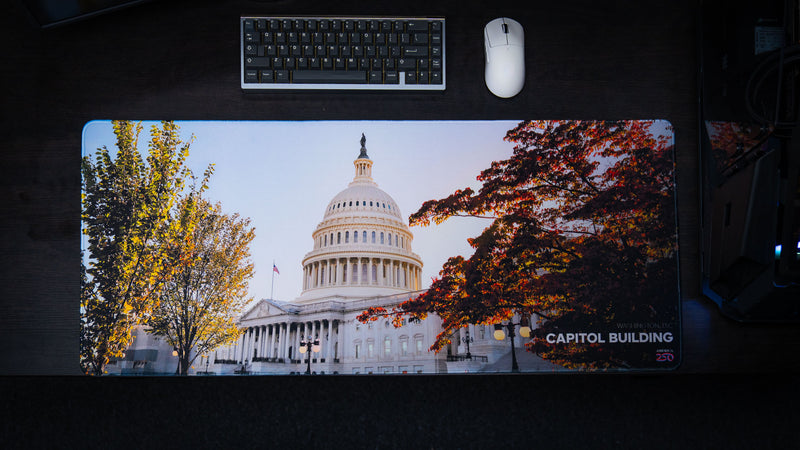 Overhead view of the Capitol Building deskmat featuring the United States Capitol framed by vibrant autumn trees in Washington, D.C., with premium stitched edges and a panoramic layout.