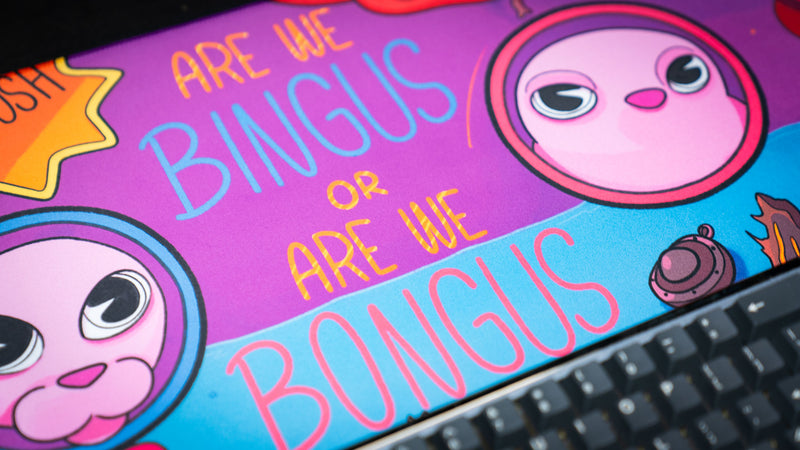 Close-up of the Bingus Bongus deskmat featuring the iconic “Are We Bingus or Are We Bongus” artwork with vibrant colors and high-definition print detail.