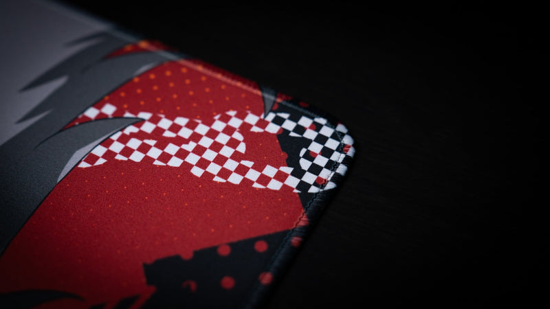Close-up of the stitched corner and red checker graphic on the CelisEris Brand Risk playmat