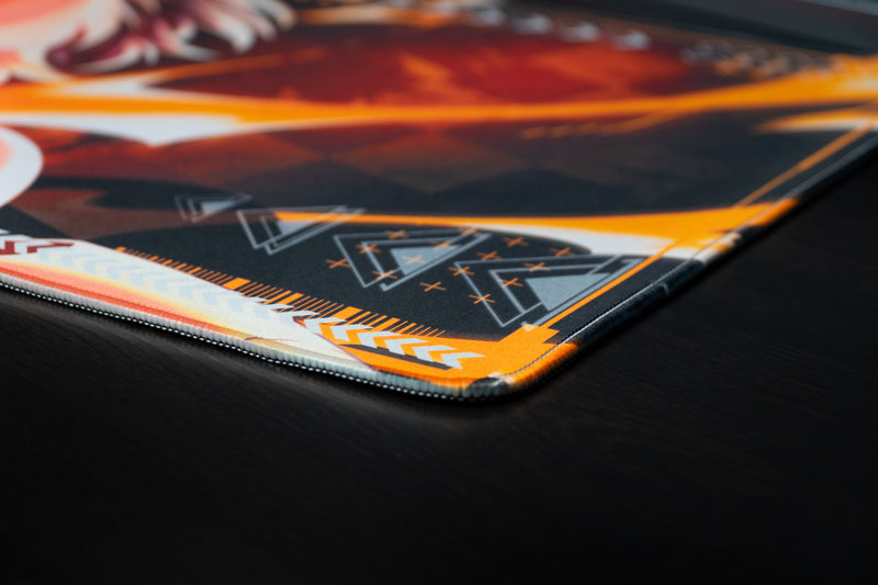 Close-up of the stitched corner and orange graphic details on the CelisEris Firewolf deskmat
