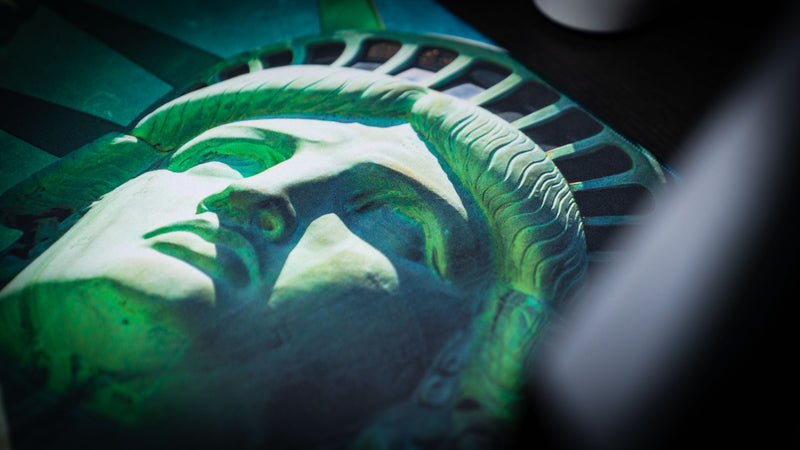 Close-up of the Statue of Liberty deskmat featuring a detailed view of Lady Liberty's face with vibrant green tones, crisp high-definition print, and premium gaming mouse pad finish.