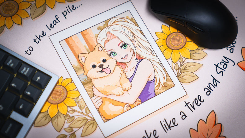 Close-up of the Cozy Desk deskmat featuring a Polaroid-style illustration of a smiling anime girl holding a fluffy Pomeranian, surrounded by sunflowers and autumn accents.