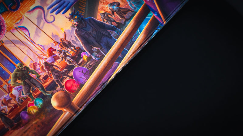 Close view of the stitched edge and carnival carousel artwork on the Festival of Feathers deskmat