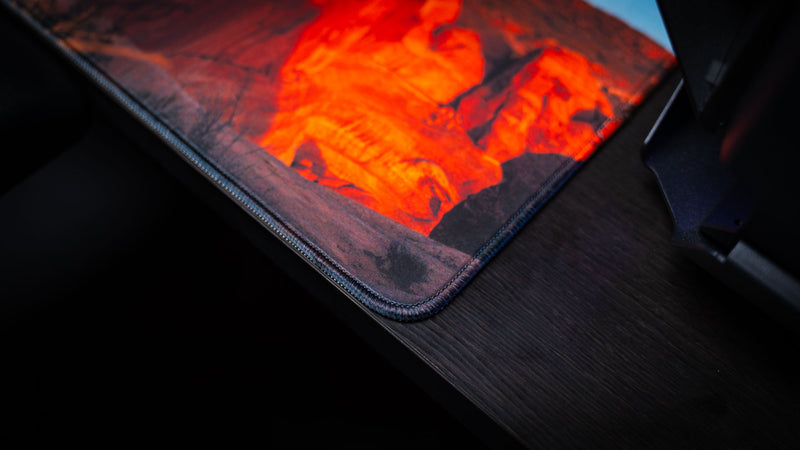 Close-up of the Death Bowl deskmat corner featuring premium stitched edges, rich red sandstone textures, and high-resolution Arches National Park photography.