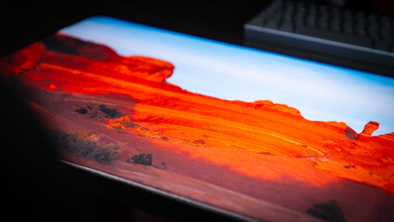 Close-up of the Death Bowl deskmat highlighting the layered red sandstone formations of Arches National Park with vibrant colors and premium stitched edges.