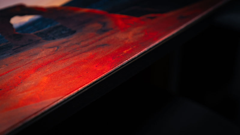 Close-up of the Delicate Arch premium deskmat highlighting precision stitched edges, vibrant Arches National Park photography, and a smooth cloth gaming surface.