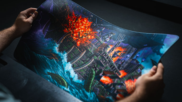Rolled deskmat edge-on, showing the stitched border and the cushioned 4 mm core