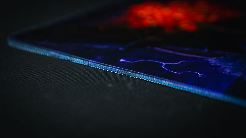 Macro close-up of the stitched edge on the Dreadmarrow TCG playmat, highlighting the premium fabric surface, precision stitching, and detailed lightning artwork