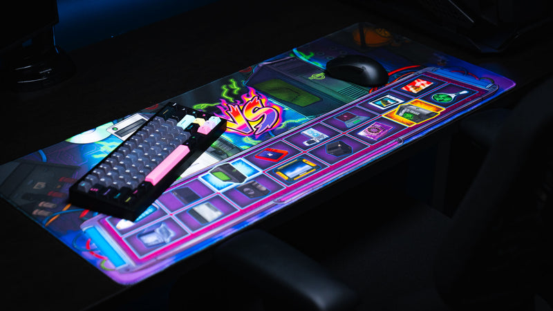RGB gaming setup featuring the E-waste Showdown deskmat by Bringus Studios with retro electronics artwork, mechanical keyboard, gaming mouse, neon colors, and collectible tech-inspired design.