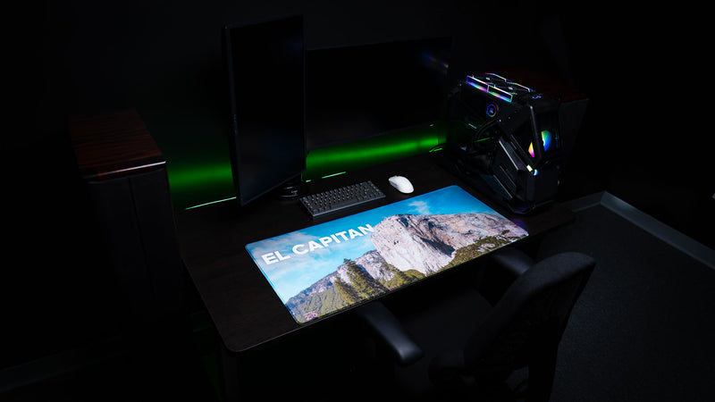 El Capitan deskmat displayed in a modern gaming desk setup, showcasing Yosemite National Park's iconic granite monolith with vibrant HD photography, premium stitched edges, and a spacious gaming surface.