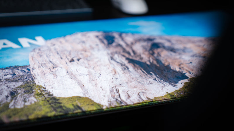 Close-up of the El Capitan deskmat showcasing Yosemite National Park's iconic granite monolith with vibrant HD photography, premium stitched edges, and a smooth gaming surface.