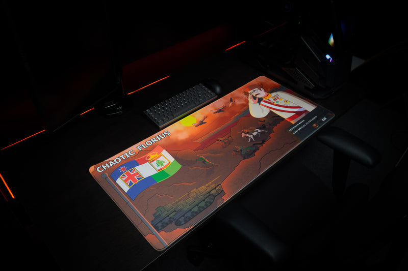 Angled view of Florius Chaotic Dawn deskmat on a dark gaming desk, with tanks, aircraft, and a decorated commander.