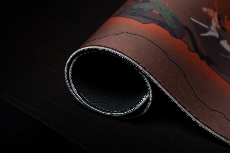 Close-up of Florius Chaotic Dawn deskmat rolled to reveal its stitched border and black backing.