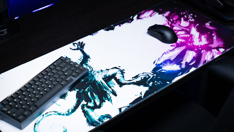 Angled view of the Forbidden Spoils premium gaming deskmat showcasing the fantasy rat warrior artwork with a mechanical keyboard, gaming mouse, and vivid purple crystal effects.