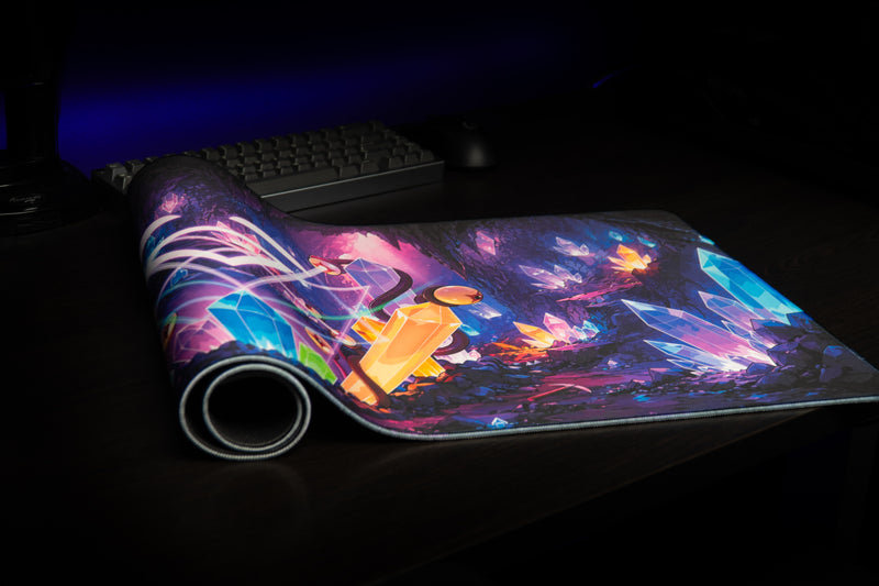 Overhead view of a keyboard and black mouse on GHOSTYMPA's Perplexray's Paradise deskmat with multicolored crystals.