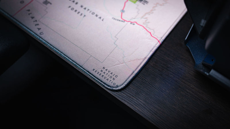 Close-up of the Grand Canyon Green deskmat highlighting the stitched corner, detailed topographic map artwork, and premium edge construction.
