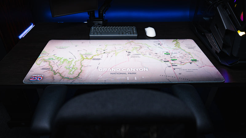 Grand Canyon Green deskmat featuring a detailed topographic map of Grand Canyon National Park displayed across a modern gaming desk with dual monitors and a mechanical keyboard.