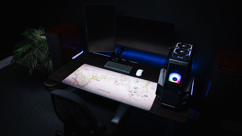 Grand Canyon Green deskmat featuring a detailed Grand Canyon National Park topographic map displayed on a modern RGB gaming desk setup with dual monitors and a custom PC.