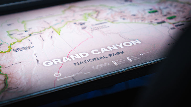 Alt text:
Close-up of the Grand Canyon Green deskmat highlighting the Grand Canyon National Park title, topographic map details, and stitched edge construction.