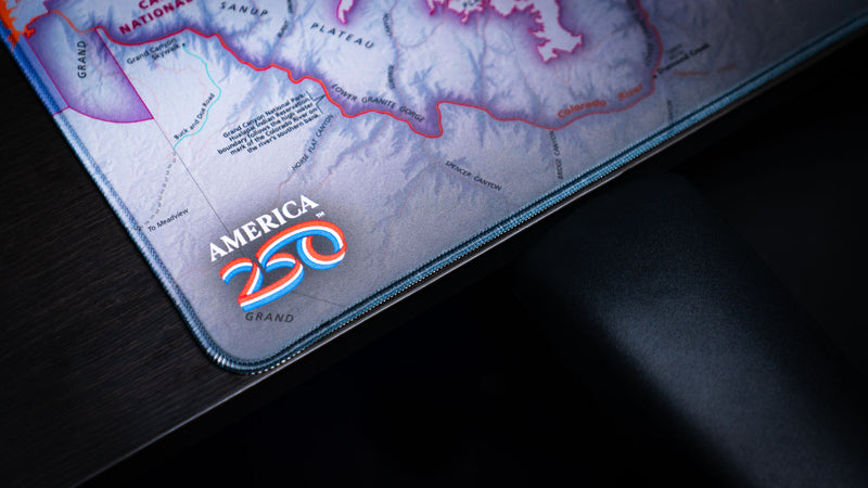 Close-up of the Grand Canyon Purple deskmat showing the America 250 logo, stitched edge, and detailed purple topographic map artwork of Grand Canyon National Park.