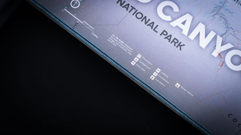 Close-up of the Grand Canyon Purple deskmat highlighting the detailed topographic map legend, park information, and premium stitched edge construction.